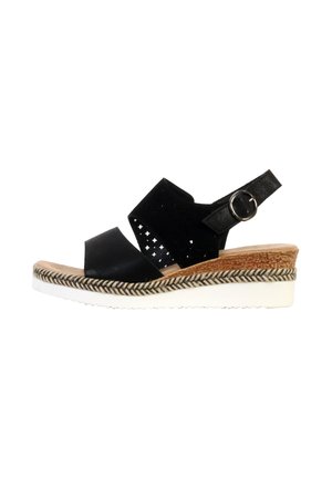 Sort kile-sandal med perforeret overdel, justerbar ankelrem med sølvspænde, flettet kant og hvid rilleret sål.