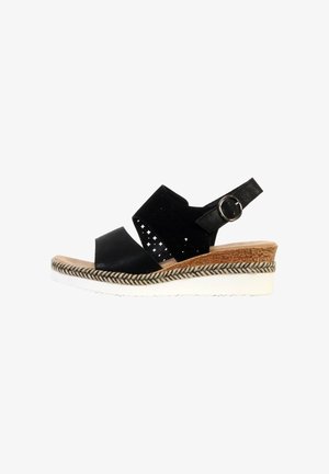 Sandalo con zeppa nero con tomaia traforata, cinturino regolabile alla caviglia con fibbia argento, rifinitura intrecciata e suola bianca dentellata.