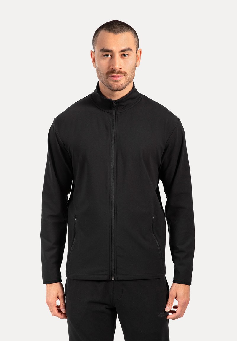 Schwarze Zip-Jacke aus weichem, dehnbarem Stoff. Mit hohem Kragen, langen Ärmeln und Vorderseite mit Reißverschlusstaschen.