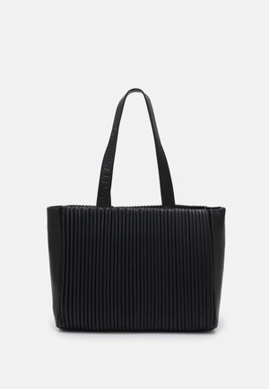 Czarna tote bag z fałdami, wykonana z gładkiej skóry, z dwoma długimi uchwytami. Posiada teksturowaną powierzchnię oraz wytłoczone logo marki na pasku.