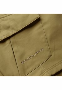 Khaki-Stoff mit genähtem Taschen Detail und gesticktem "ENDURA"-Logo in hellbraun. Glatte Textur mit matter Oberfläche.