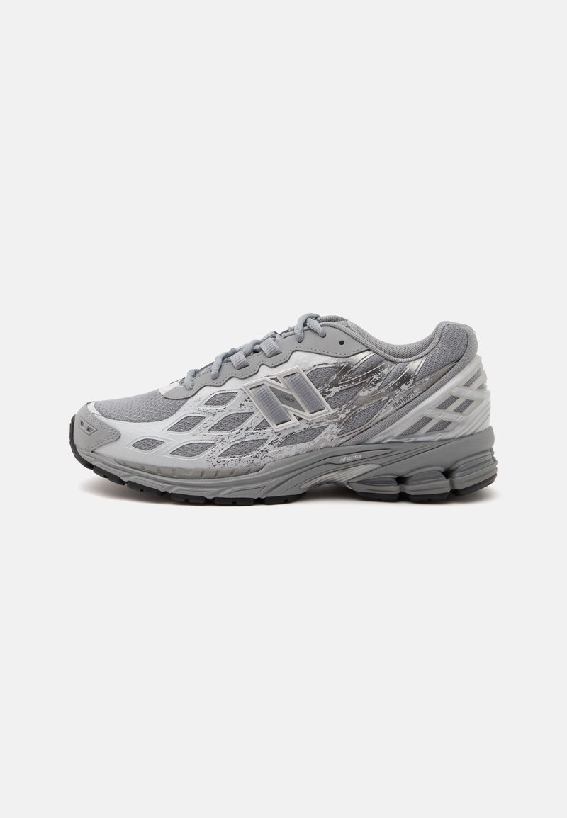Светлосив и бял спортен обувки с мрежест горен материал, шарен страничен панел, омекотена подметка и връзки, показан от външната страна.