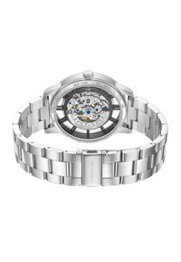 Montre en acier inoxydable argenté avec un fond de boîtier transparent, mettant en valeur des engrenages complexes et des accents colorés. Dispose d'un bracelet à maillons.