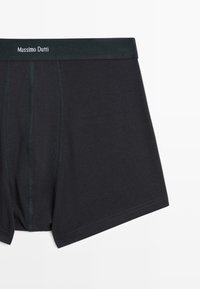 Svarta bomullsboxershorts med en åtsittande design, som har ett mörkgrönt elastiskt midjeband med "Massimo Dutti" tryckt i vitt.
