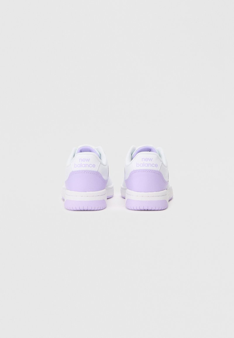 Baskets New Balance, blanches et lavande, en matériau synthétique lisse, avec un col rembourré et une semelle à texture antidérapante. Logo de la marque au talon.
