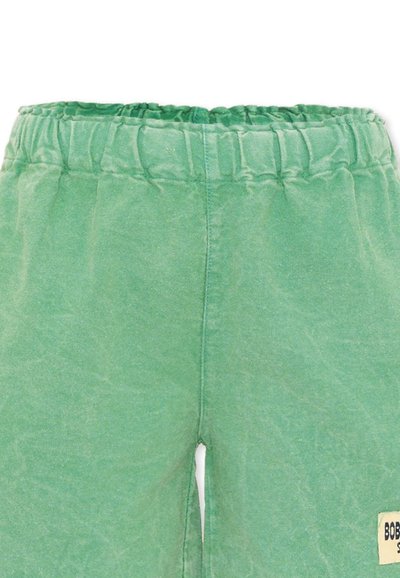 Shorts verts à taille élastique avec des coutures visibles et une petite étiquette beige sur la jambe droite.