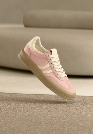 Baskets roses avec une tige en cuir lisse, des accents crème, une semelle extérieure texturée et des lacets blancs. Design simple avec des détails de bandes latérales.