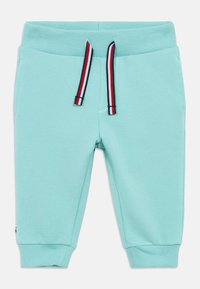 Heledad sinine dressipüksid ribatud vöökoha ja cuffsiga. Omab punaseid, valgeid ja tumesiniseid nööraktsente ning küljetaskuid. Sile tekstuur.