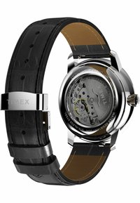 Timex watch with a black leather band, stainless steel case, transparent back showing the mechanism, and silver hardware accents.