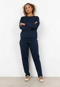 Navyblauwe sweatshirt en bijpassende broek, gemaakt van een zachte stof, met een ronde hals en lange mouwen, in een ontspannen pasvorm.