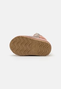 Mou botas su pink oda, su tekstūruota, banguota guma apatine dalimi ir nutrintomis tekstilinėmis detalėmis.