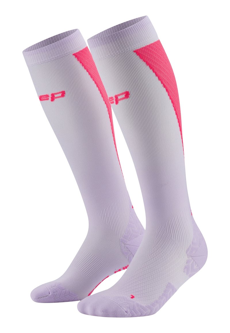 Calze a compressione di un leggero viola con accenti rosa. Presentano un design testurizzato, un tallone rinforzato e il logo. Materiale liscio per il comfort.