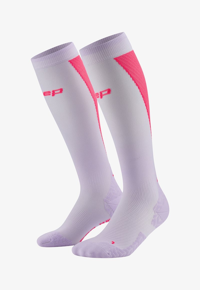 Calze a compressione di un leggero viola con accenti rosa. Presentano un design testurizzato, un tallone rinforzato e il logo. Materiale liscio per il comfort.