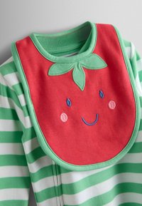 Tissu rayé vert et blanc avec un bavoir rouge présentant un visage de fraise souriant, des accents de feuilles vertes et des détails brodés.