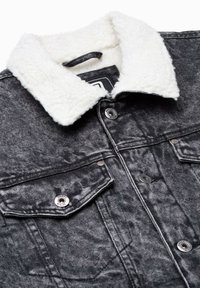 Giacca di jeans nera con colletto in shearling bianco, caratterizzata da bottoni argentati, due tasche sul petto e un dettaglio in tessuto testurizzato.