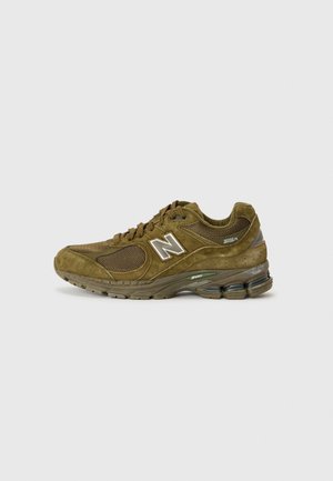 Brun New Balance løbesko med mesh og ruskind detaljer, polstret sål og "2002R" modelmærkning på siden.