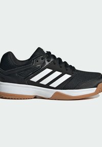 Scarpa sportiva nera con tomaia in mesh, tre strisce bianche e suola in gomma color camoscio. Design elegante con collarino imbottito e lacci.