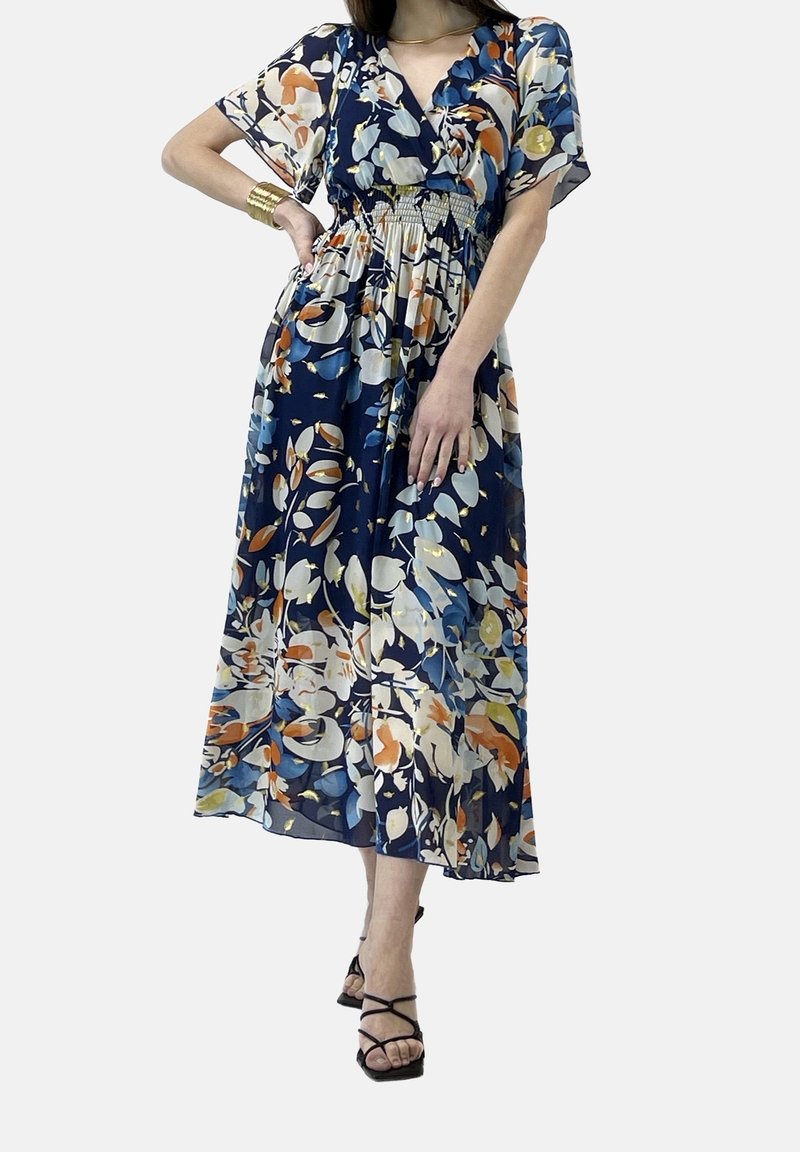 Kukallinen maksimekko, jossa on tummansininen tausta ja monivärisiä kuvioita. Valmistettu kevyestä kankaasta, se sisältää V-pääntien ja joustavan vyötärön.