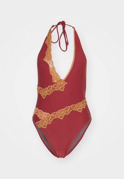 Κόκκινο ολόσωμο μαγιό με βαθύ V-λαιμό, διακοσμημένο με χρυσές δαντελένιες λεπτομέρειες και χαρακτηριστικό δέσιμο στο πίσω μέρος. Απαλή ύφανση με ελαφριά γυαλάδα.