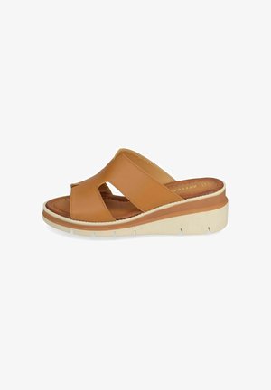 Sandalo marrone in pelle con cinturini incrociati, soletta imbottita e suola piattaforma beige con fondo scolpito.