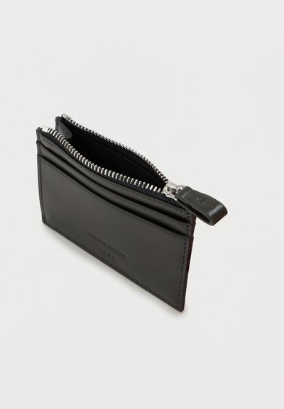 Czarny skórzany portfel na karty z zamkiem błyskawicznym, wyposażony w liczne sloty na karty oraz srebrne okucia do zamykania. Gładka faktura całości.