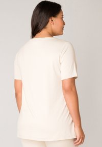 Korte mouw beige t-shirt gemaakt van zachte katoen, met een ronde halslijn, een relaxte pasvorm en een gladde textuur zonder zichtbare patronen.