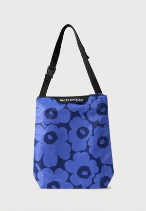 Blue tote bag with large dark blue floral pattern, black adjustable shoulder strap, and "marimekko" label near zipper.