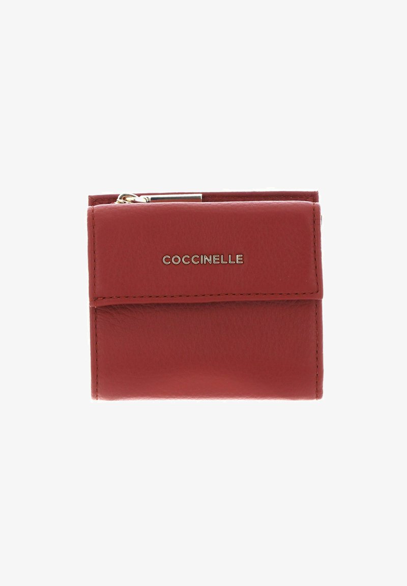 Portefeuille rouge compact en cuir avec bords cousus, fermeture à rabat, fermeture éclair métallique sur le dessus, et le nom de la marque « COCCINELLE » en lettres métalliques au centre devant.