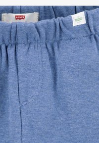 Shorts in cotone azzurro chiaro con vita elasticizzata arricciata e tasche laterali. Presenta il marchio Levi's sull'etichetta. Texture morbida.