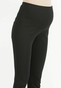 Black maternity leggings featuring a soft, stretchy fabric, high waistband, and side pockets for added functionality.