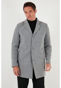Abrigo de lana gris con solapa con muesca, diseño de un solo botón, dos bolsillos delanteros y un bolsillo en el pecho. Textura suave, detalles con botones.