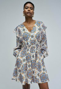 Vestido de manga corta con estampado floral en crema, azul y naranja. Presenta un escote en V y una cintura fruncida para un ajuste relajado.