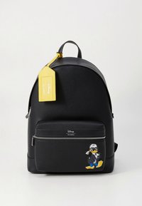 Svart ryggsäck i texturerat läder med en framficka med dragkedja som pryds av en tecknad karaktär. Inkluderar en gul tagg med Disney-märkning.