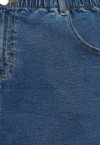 Denimová tkanina v tmavě modré barvě se hladkým povrchem, se zapínáním na knoflík a zip, a s vyztuženým švem podél okrajů.