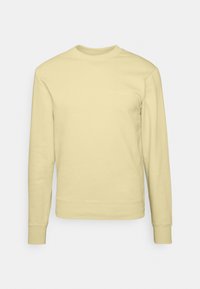 Sudadera amarilla hecha de una tela suave, con cuello redondo, mangas largas y puños acanalados, y un logotipo sutil impreso en el pecho.