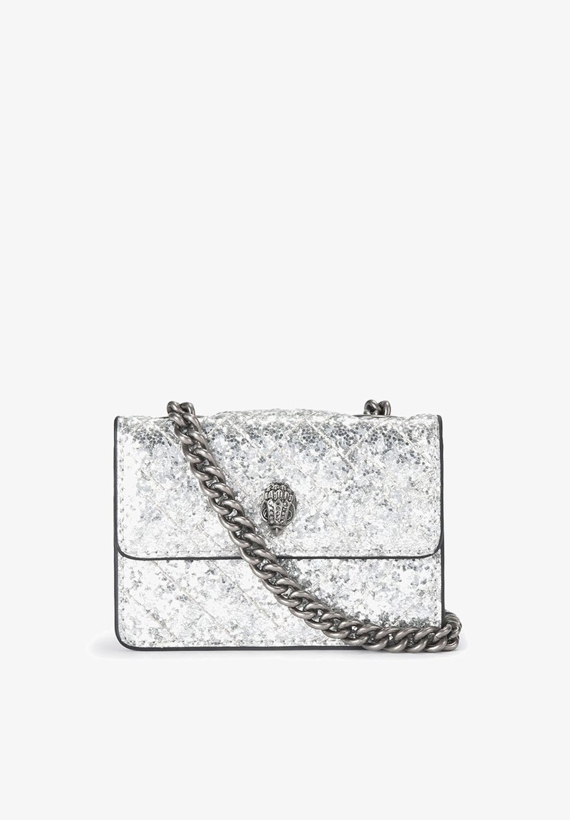 Sac à main en cuir matelassé argenté avec une bandoulière chaîne métallique et un fermoir décoratif. Présente une surface texturée avec des détails de coutures diagonales.