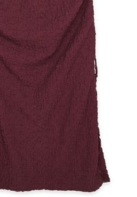 Bordeaux gekreukt stof met een gerimpeld oppervlak. Heeft ongelijke randen en een zachte, lichte uitstraling.