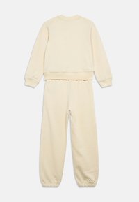 Crème-kleurige sweatsuit met een sweatshirt met ronde hals en broek met elastische tailleband en cuffs bij de enkels, gemaakt van zachte, textuurrijke stof.