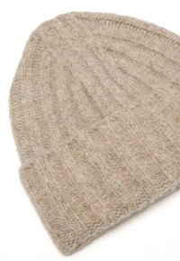 Berretto di lana lavorato a maglia beige con texture a coste e visiera piegata, posato su uno sfondo bianco.