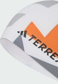 Bílá čepice s oranžovým a šedým geometrickým vzorem a černým textem "TERREX". Vyrobena z hladkého, elastického materiálu.