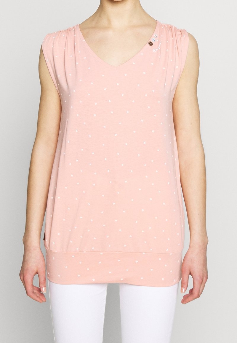 Top rosa a maniche corte con scollatura a V, pois bianchi, orlo arrotondato e bottoni decorativi sulla spalla. Realizzato in tessuto morbido.