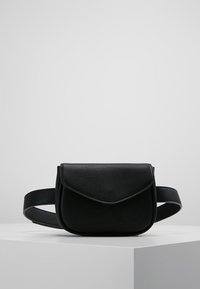 Marsupio in pelle nera con chiusura a patta curva, cinturino regolabile e texture liscia, caratterizzato da un design minimalista e compatto.