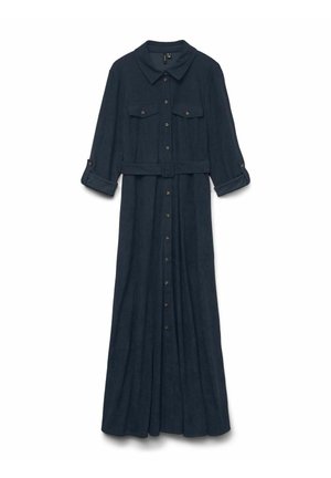 Lång marinblå klänning med krage, två bröstfickor och knappstängning. Har en bälte vid midjan och uppvikta ärmar för en lager på lager-look.