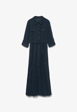 Lång marinblå klänning med krage, två bröstfickor och knappstängning. Har en bälte vid midjan och uppvikta ärmar för en lager på lager-look.