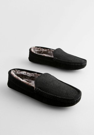 Schwarze Wildlederschuhe mit strukturierten Oberflächen, Innenfutter aus Fell und flacher Sohle. Einfaches, rutschfestes Design für Komfort und Wärme.