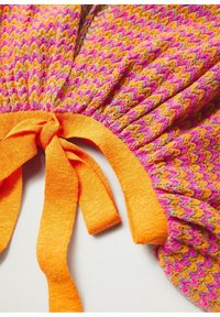 Vêtement en maille texturée avec un motif en zigzag rose, orange et jaune. Doté d'un lien orange à la taille.