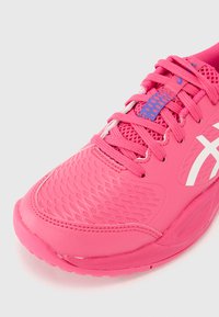 Rosa Laufschuh mit Mesh-Obermaterial, strukturiertem Design, weißem Logo und kontrastierendem blauen Akzent an der Zunge. Verfügt über flache Schnürsenkel und Gummisohle.
