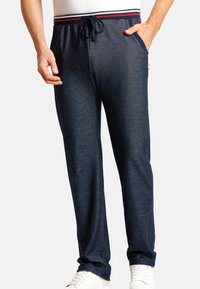 Navy Loungehosen mit einem Kordelzugbund, versehen mit rot-weißen Streifen, seitlichen Taschen und einem lockeren Schnitt. Weicher, strukturierter Stoff.