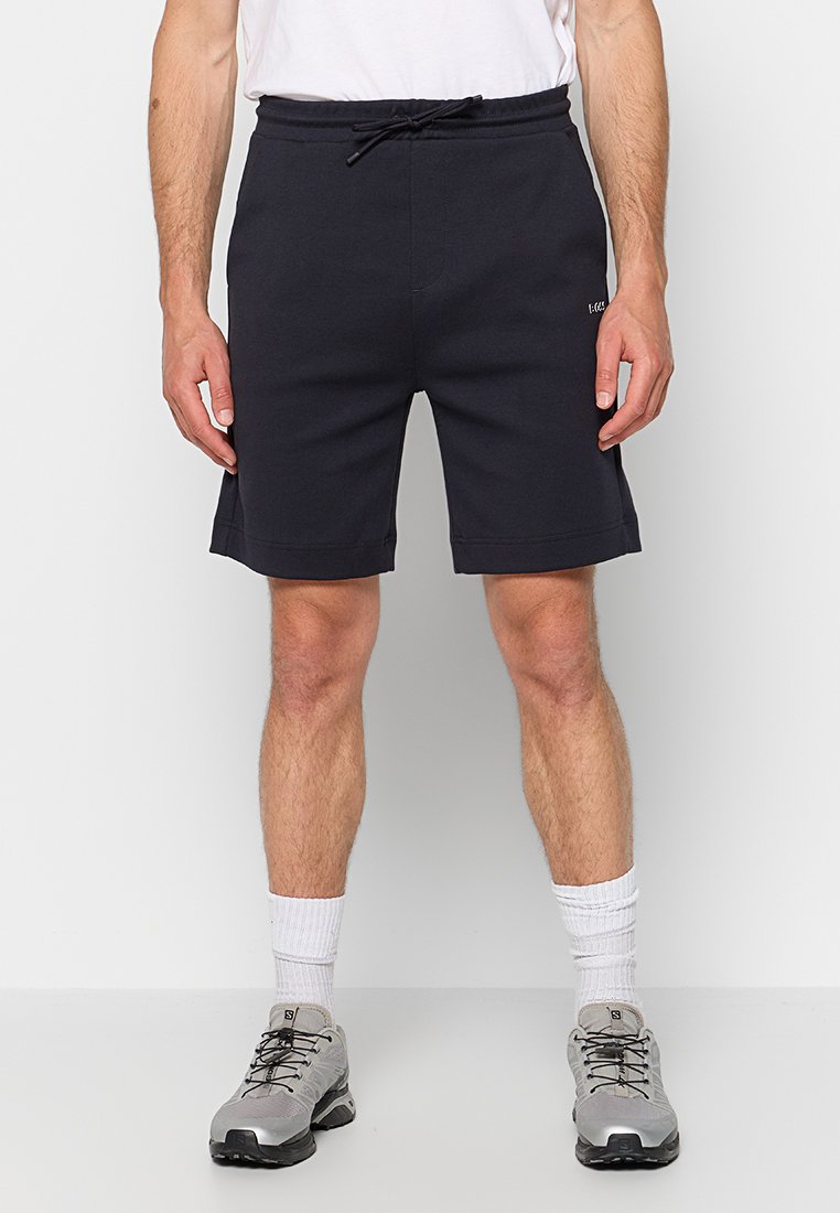 Shorts de sport gris foncé avec ceinture élastique et cordon de serrage. Comprend deux poches latérales et une coupe décontractée, fabriqués en matière doux en mélange de coton.