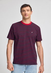 Marinrandig t-shirt med röda ränder och röd krage. Har en liten logotyp på vänster bröst. Tillverkad av mjukt, andningsbart tyg.